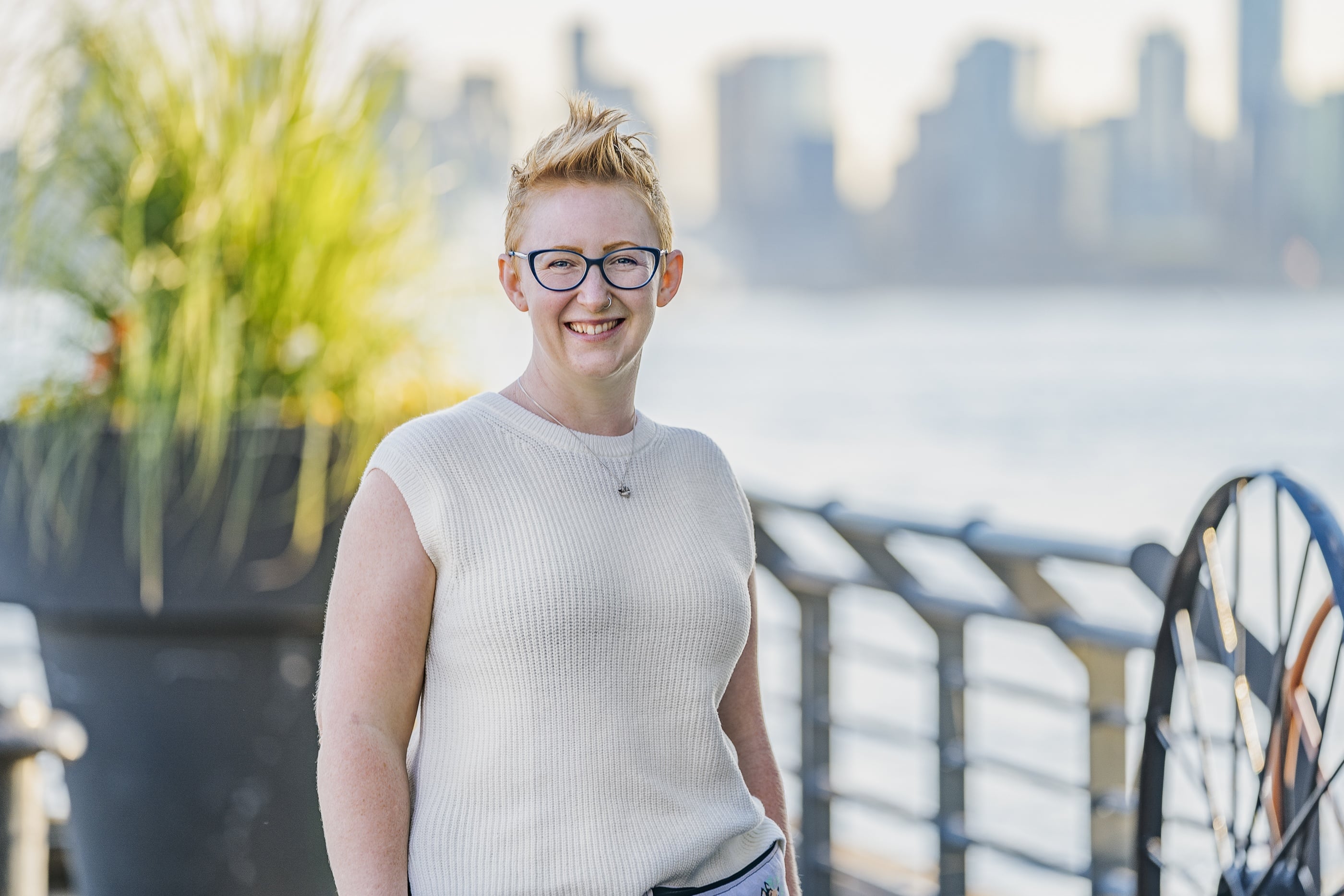 Headshot of Kaeli Grotz, owner of Fluff in the Forest Dog Training. They have short blonde hair and blue glasses